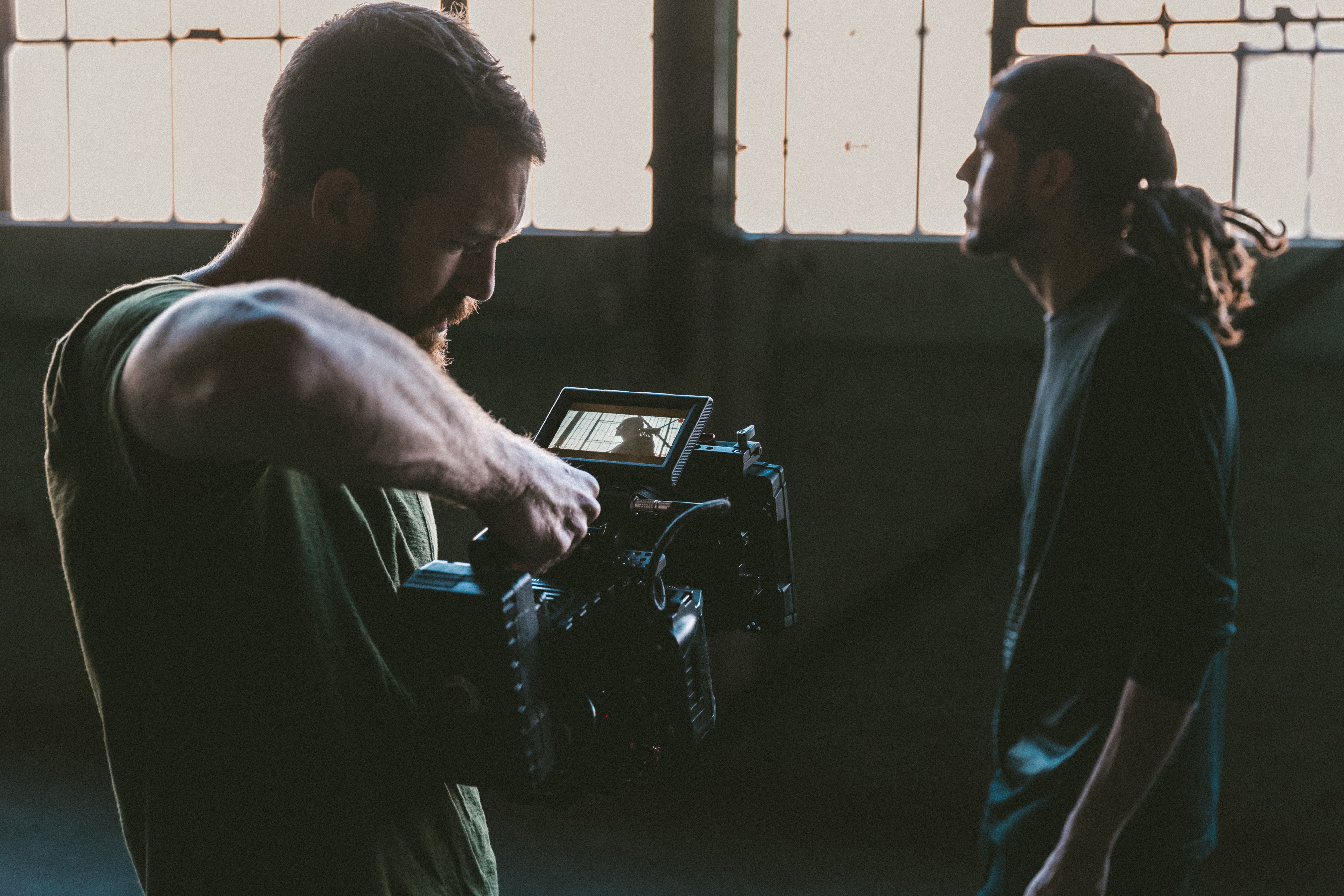 A man holding a professional video camera in an indoor environment